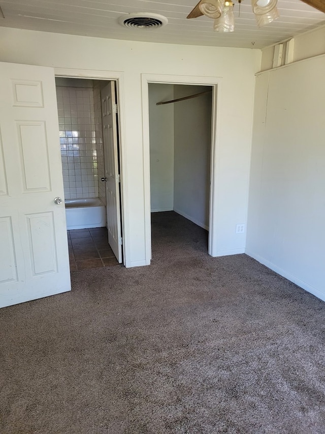 405 E 41st St, San Angelo, TX 76903 - unfurnished bedroom featuring dark carpet, a walk in closet, a closet, and ensuite bathroom