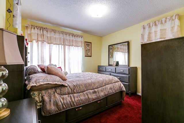 bedroom with a textured ceiling and dark carpet