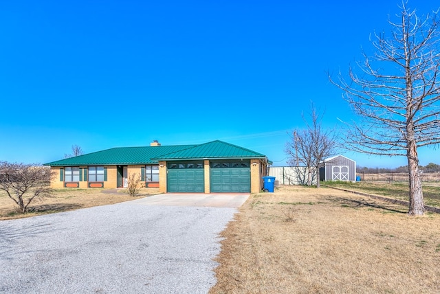 view of front of house with a garage, a shed, and a front lawn