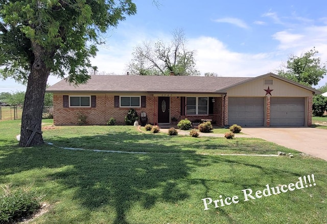 single story home with brick siding, an attached garage, a front yard, and concrete driveway