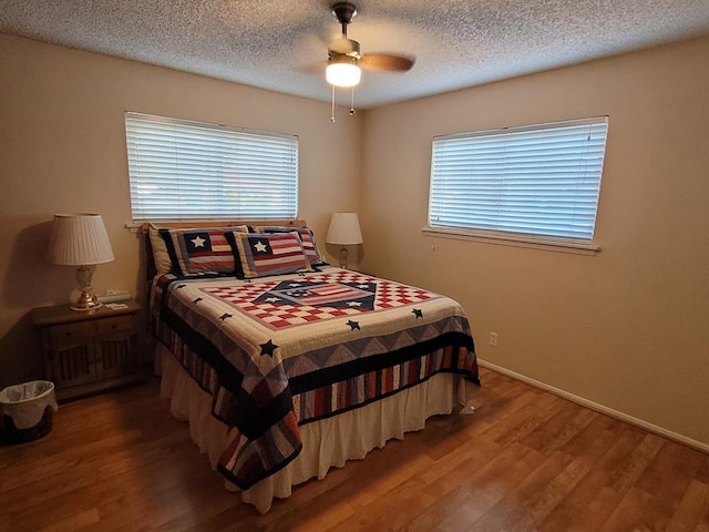 bedroom featuring hardwood / wood-style flooring, ceiling fan, and a textured ceiling