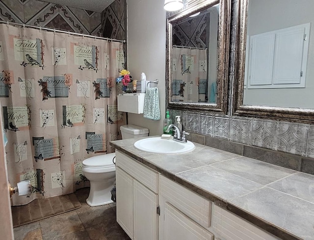 bathroom with vanity, a textured ceiling, and toilet