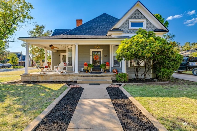 1325 S David St, San Angelo, TX 76901 - view of front facade featuring covered porch, a front lawn, roof with shingles, a ceiling fan, and a chimney