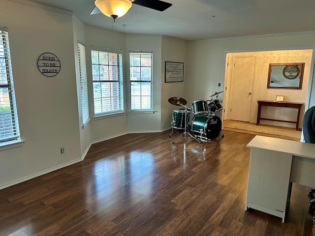 living area with crown molding, dark wood-type flooring, and ceiling fan