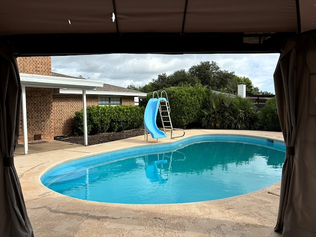 view of pool featuring a patio and a water slide