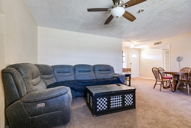 carpeted living room with ceiling fan and a textured ceiling