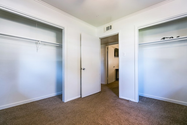 unfurnished bedroom featuring crown molding, dark carpet, and a closet