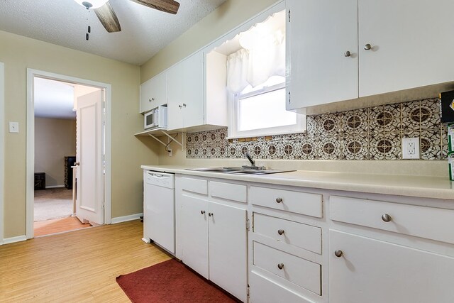 kitchen featuring sink, white dishwasher, ceiling fan, light hardwood / wood-style floors, and white cabinets