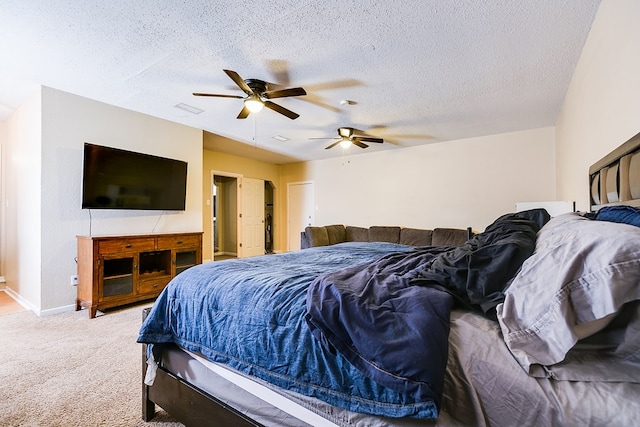 bedroom with ceiling fan, carpet, and a textured ceiling