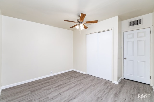 unfurnished bedroom with ceiling fan, a closet, and light wood-type flooring