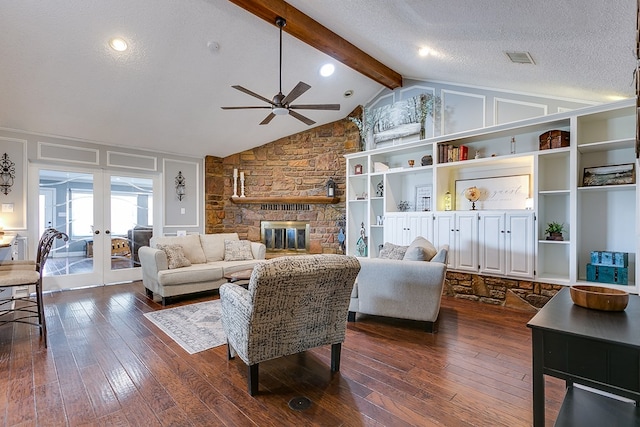 living room with ceiling fan, lofted ceiling with beams, a fireplace, dark wood-style floors, and a textured ceiling