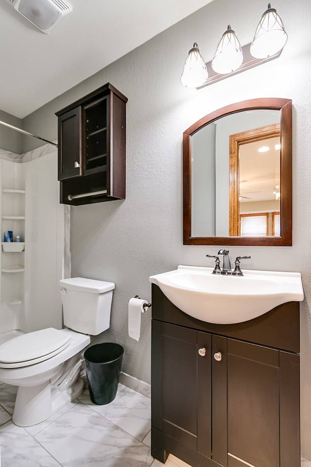 full bath with toilet, marble finish floor, baseboards, walk in shower, and vanity