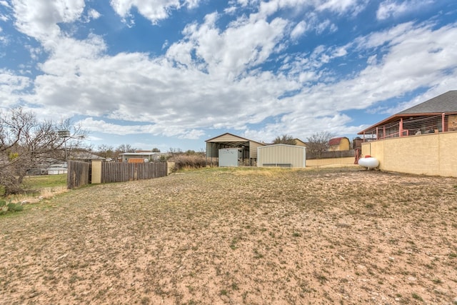 view of yard with an outbuilding, a pole building, and fence