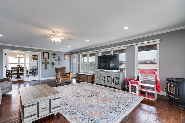 living room with baseboards, wood-type flooring, a healthy amount of sunlight, and a wood stove