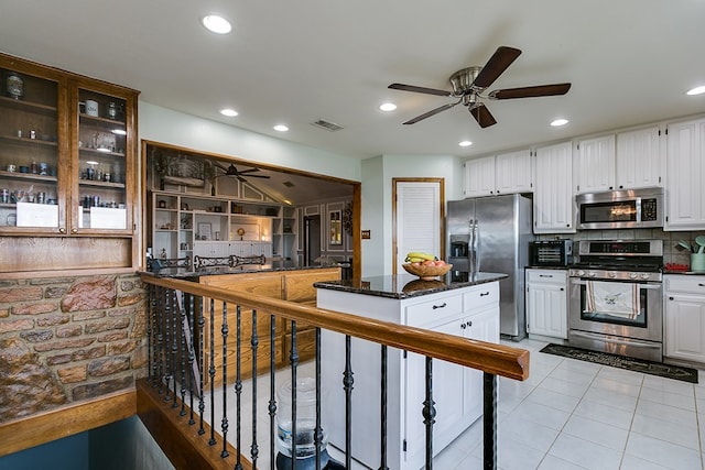 kitchen featuring light tile patterned floors, white cabinetry, appliances with stainless steel finishes, and tasteful backsplash