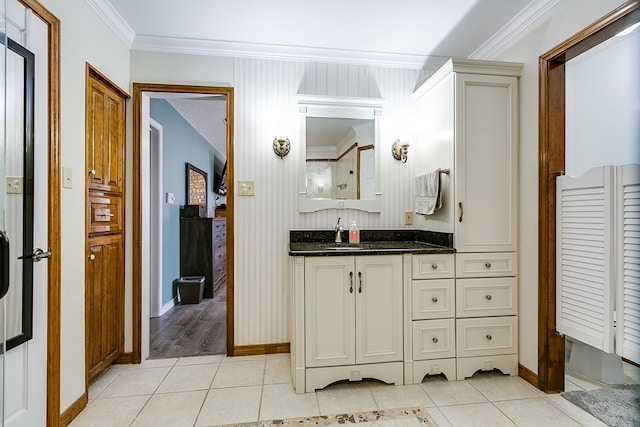 bathroom featuring tile patterned floors, vanity, baseboards, and ornamental molding