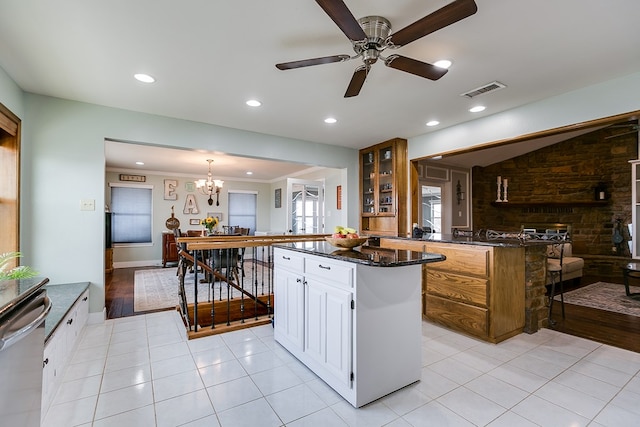 kitchen with visible vents, white cabinetry, dark stone counters, glass insert cabinets, and dishwasher