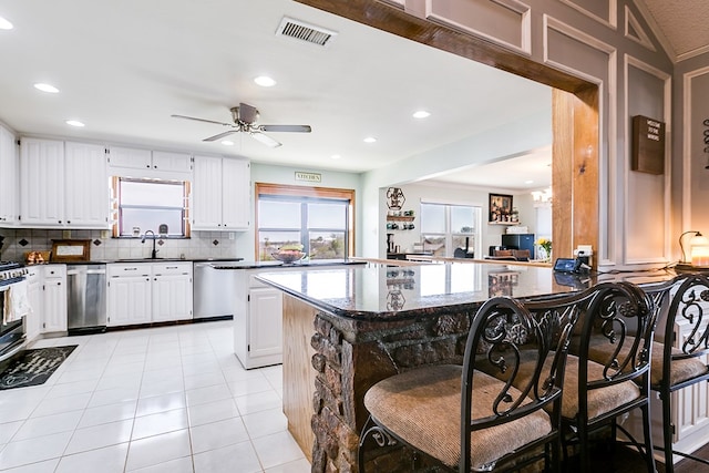 kitchen with light tile patterned floors, visible vents, dishwasher, and decorative backsplash