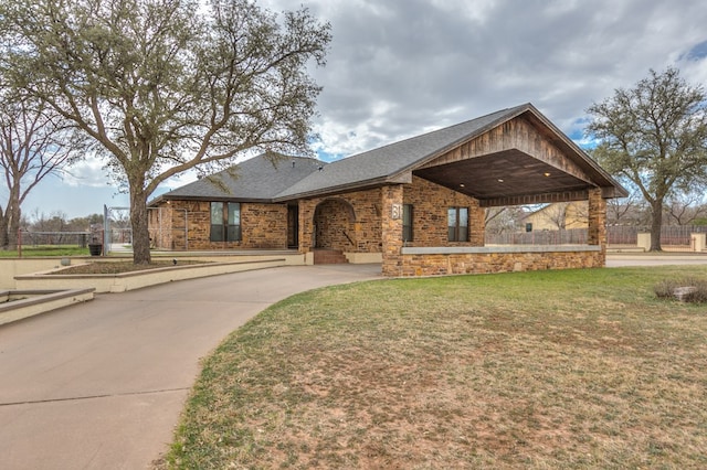 view of front of property with a front lawn, fence, brick siding, and a shingled roof