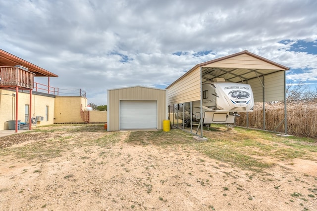 view of outdoor structure featuring an outdoor structure, a carport, and driveway