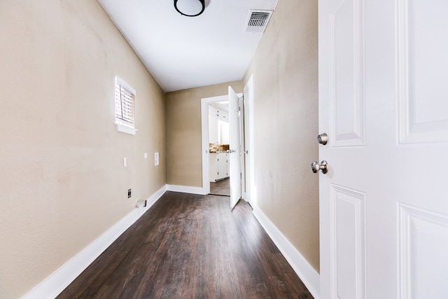 laundry area featuring baseboards, visible vents, and dark wood-type flooring