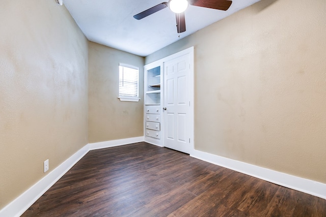 unfurnished room with ceiling fan, baseboards, and dark wood finished floors