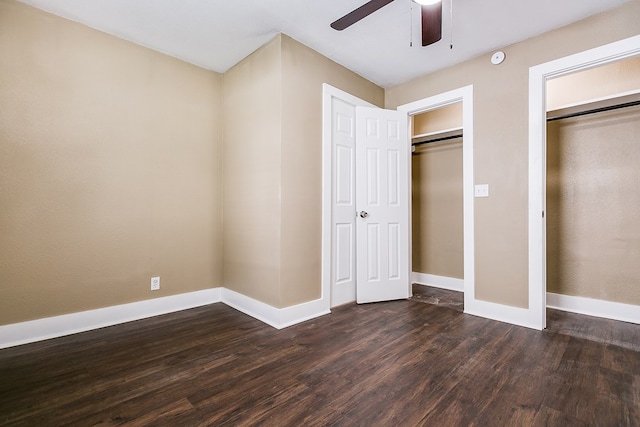 unfurnished bedroom featuring dark wood finished floors, a ceiling fan, and baseboards