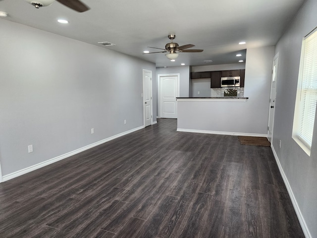 unfurnished living room featuring dark hardwood / wood-style flooring and ceiling fan