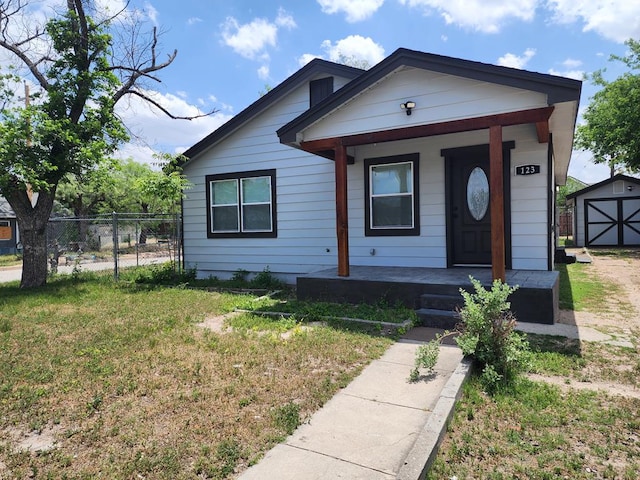 bungalow-style home featuring a porch, a shed, and a front yard