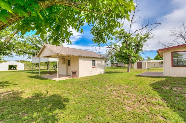 4302 Homestead Cir, Wall, TX 76903 - view of grassy yard with an outbuilding, a carport, and a patio area