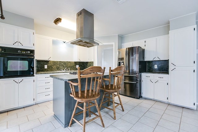 4302 Homestead Cir, Wall, TX 76903 - kitchen featuring black oven, stainless steel fridge, island range hood, and light tile patterned flooring