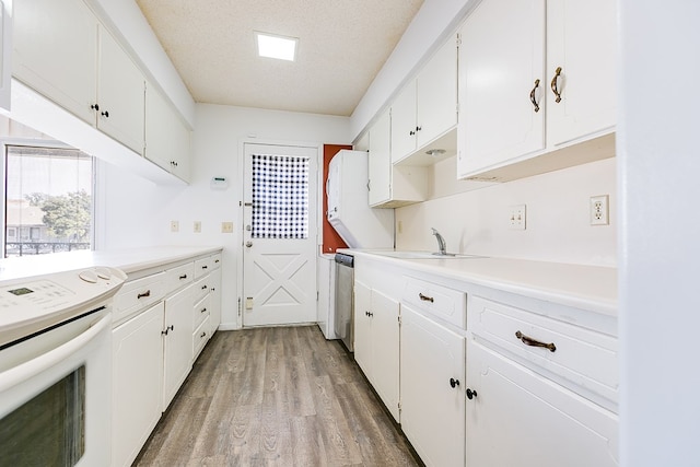 kitchen with white cabinetry, sink, electric range, and a textured ceiling