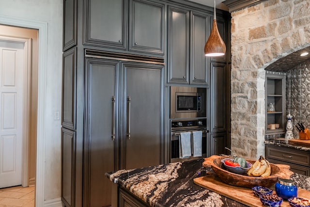 kitchen featuring built in appliances and dark stone countertops