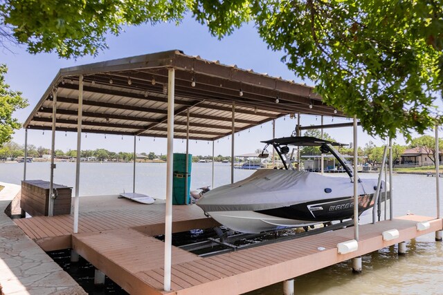 dock area featuring boat lift and a water view