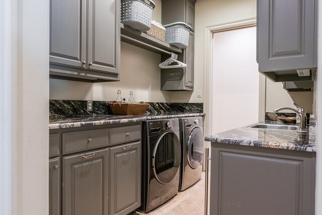 laundry area with a sink, light tile patterned flooring, bar area, washing machine and clothes dryer, and cabinet space