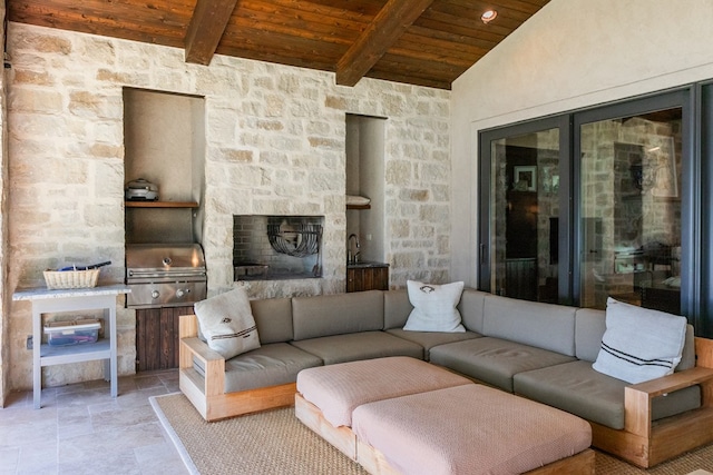 living room featuring beamed ceiling, an outdoor stone fireplace, stone finish flooring, wooden ceiling, and high vaulted ceiling