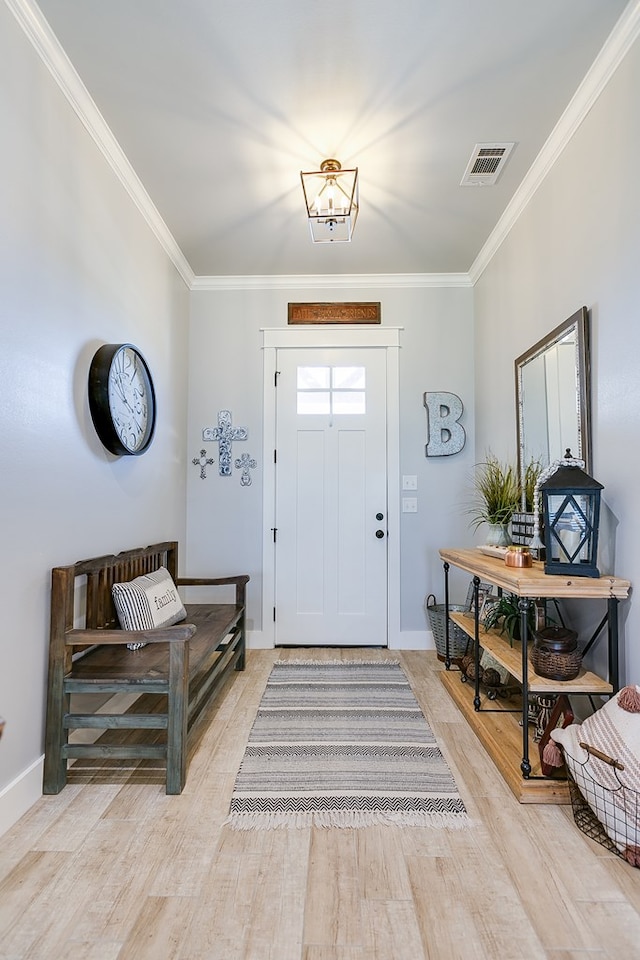 foyer featuring light wood-style flooring, visible vents, baseboards, and ornamental molding
