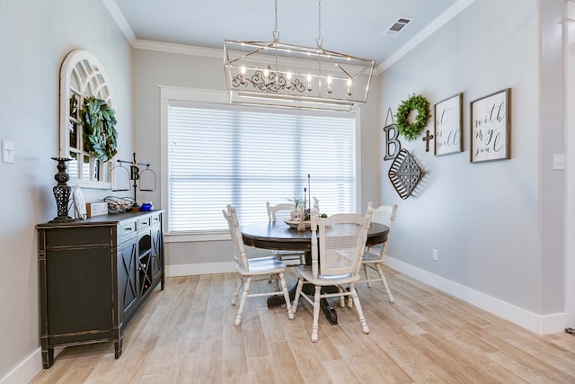 dining room featuring an inviting chandelier, ornamental molding, visible vents, and baseboards