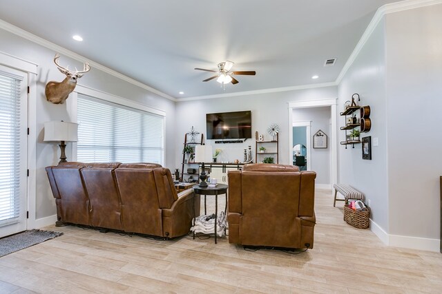 living area featuring light wood finished floors, a wealth of natural light, and a ceiling fan