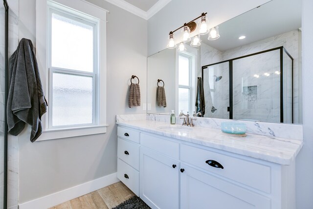 bathroom with a shower stall, wood finished floors, vanity, baseboards, and ornamental molding