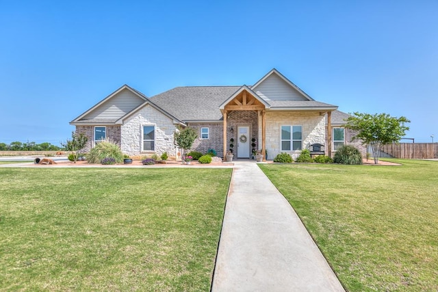view of front of property with a front lawn, fence, stone siding, and a shingled roof