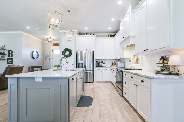 kitchen featuring stainless steel appliances, ornamental molding, a sink, custom exhaust hood, and a notable chandelier