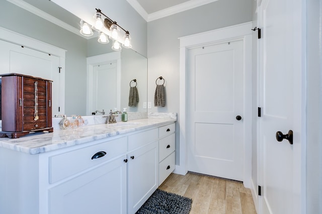 bathroom featuring wood finished floors, vanity, and ornamental molding