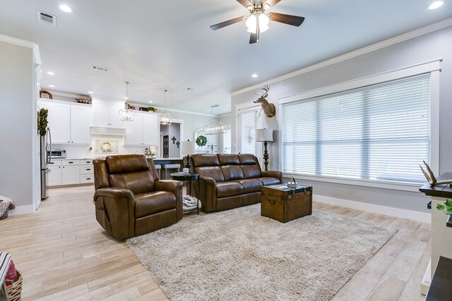 living room with light wood-style floors, visible vents, and ceiling fan