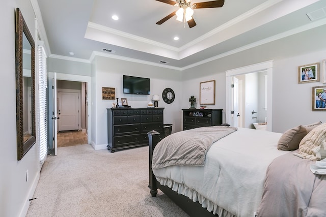 bedroom featuring a raised ceiling, visible vents, crown molding, and light colored carpet