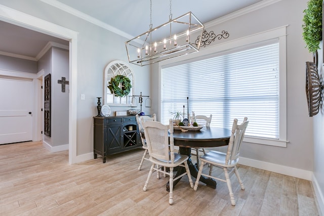 dining space with light wood finished floors, baseboards, a notable chandelier, and ornamental molding