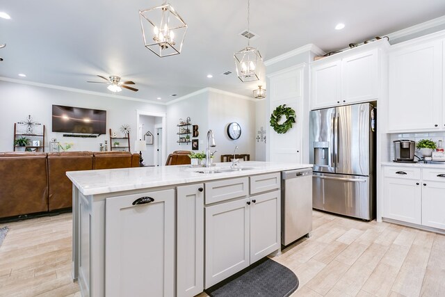 kitchen featuring white cabinets, stainless steel appliances, a sink, a center island with sink, and recessed lighting