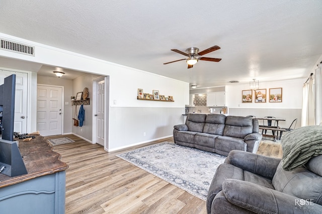 412 E Holmes Ave, Bronte, TX 76933 - living room featuring light wood-type flooring, a ceiling fan, and a chandelier