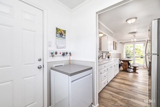 412 E Holmes Ave, Bronte, TX 76933 - kitchen with white cabinets, freestanding refrigerator, ornamental molding, and light wood-style floors