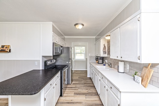 412 E Holmes Ave, Bronte, TX 76933 - kitchen with stainless steel appliances, light wood-style flooring, white cabinets, and backsplash